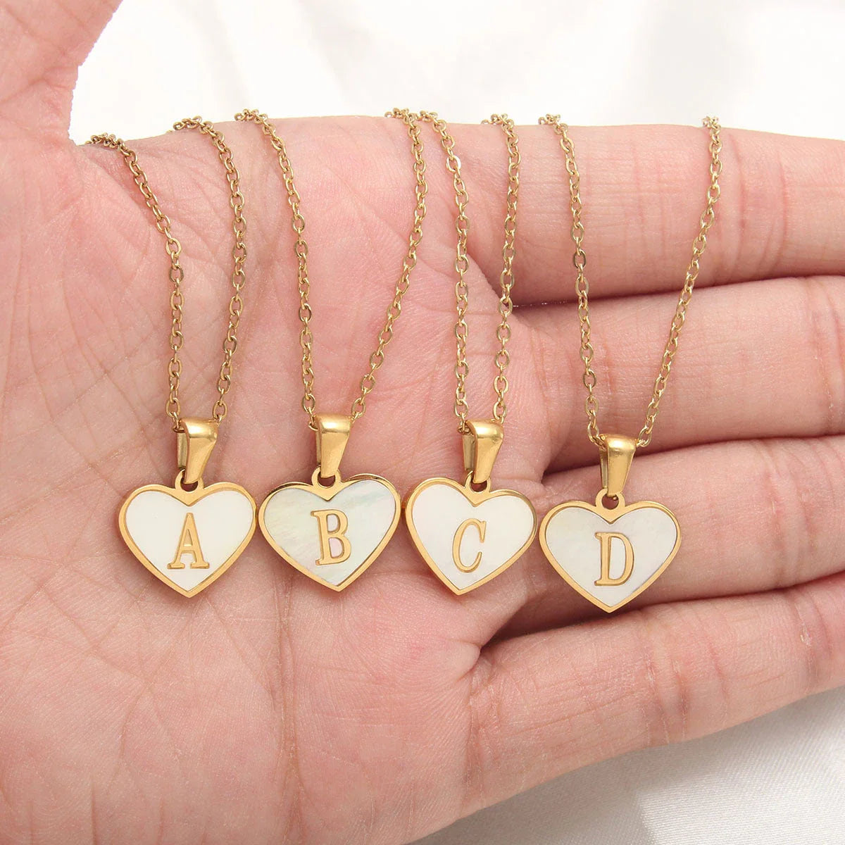 A personalized heart-shaped necklace with a 26-letter charm, crafted from high-quality stainless steel and gold plating.