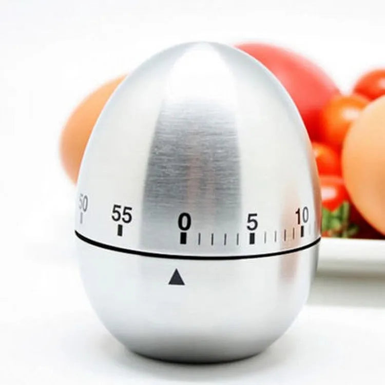 Stainless steel egg-shaped mechanical kitchen timer on a kitchen counter