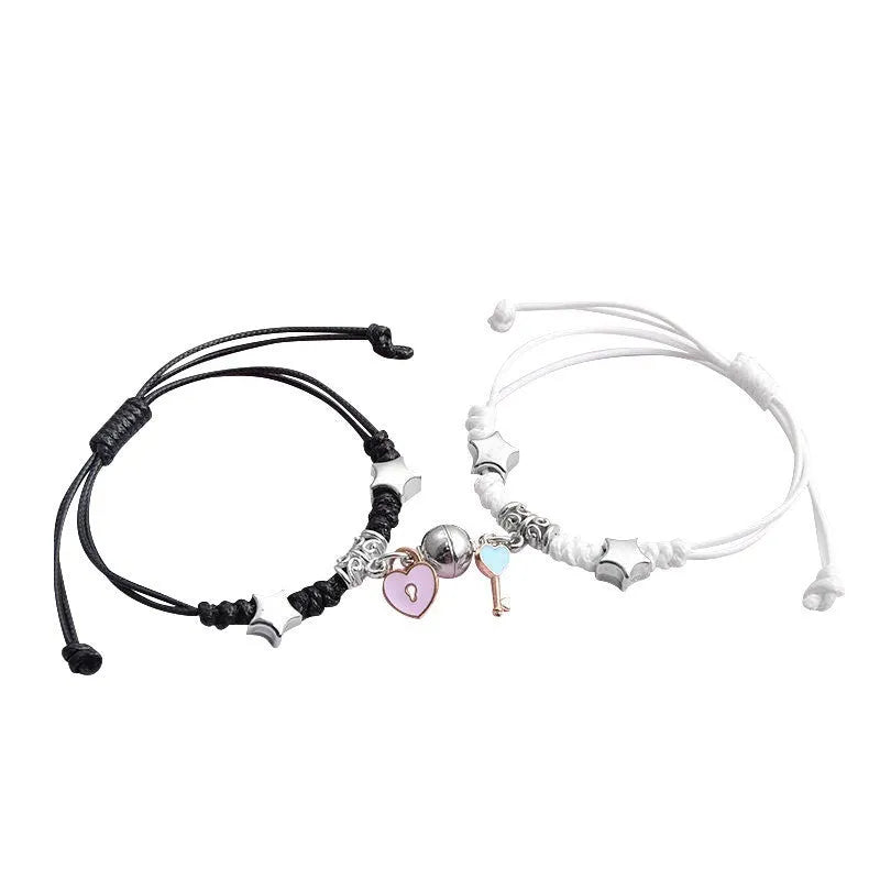 Pair of magnetic alloy bracelets with crown and heart charm designs on a wrist.