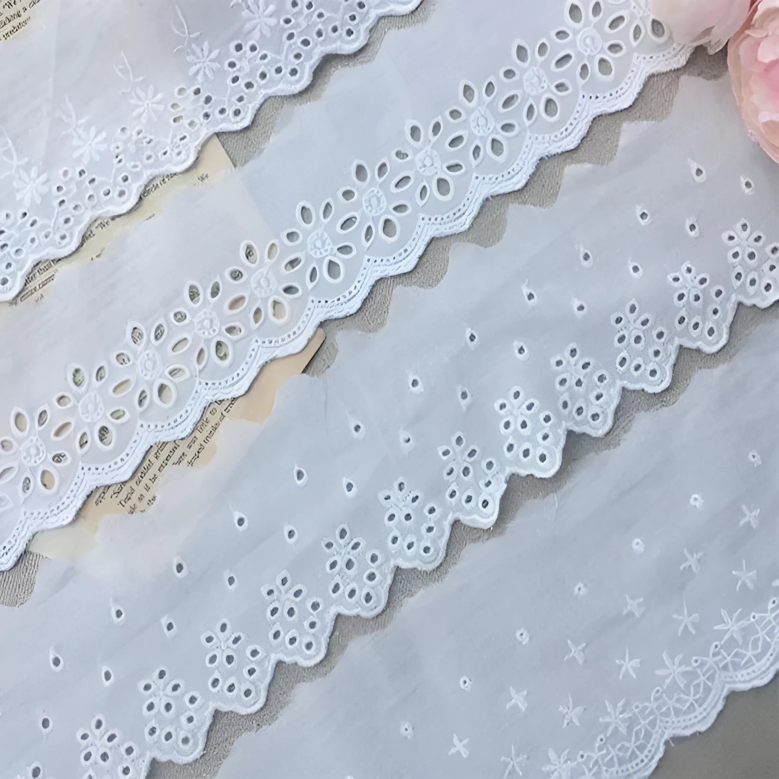 Close-up of white cotton embroidered lace trim showing cut-out pattern, with four width style options for DIY sewing.