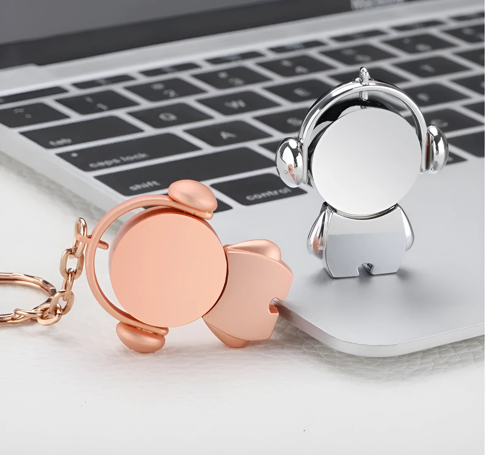 Silver and rose gold metal USB flash drives with a cartoon musician graphic, showing front and side views.