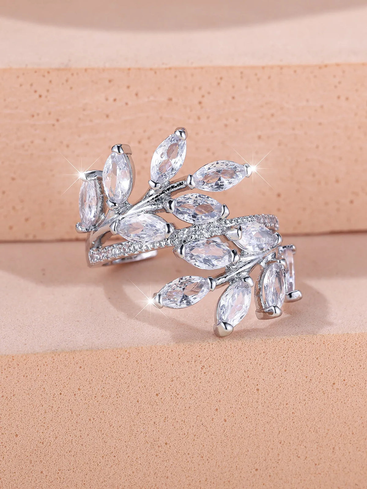 Adjustable copper leaf ring with a horse eye zircon stone in multiple colour finishes on a neutral background.
