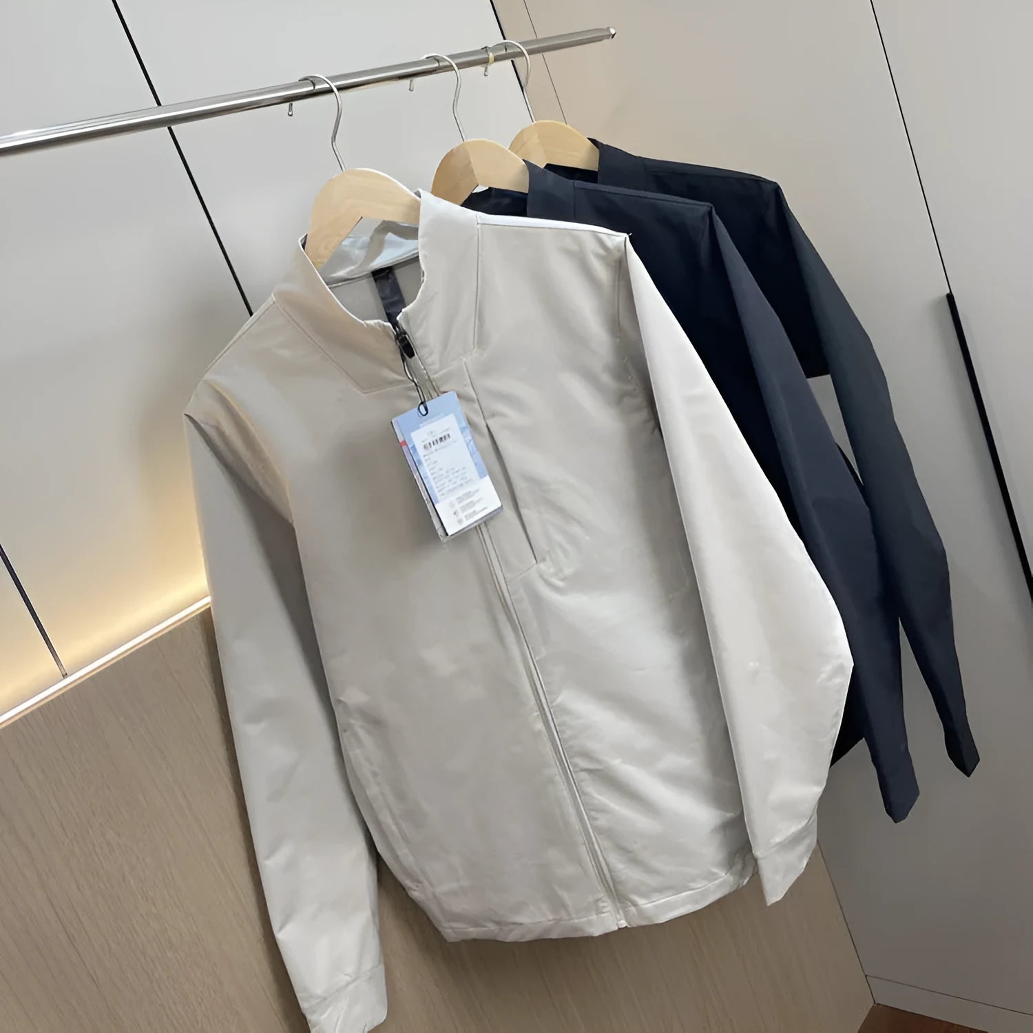 Man wearing a beige stand collar polyester casual jacket with long sleeves and a straight hem.