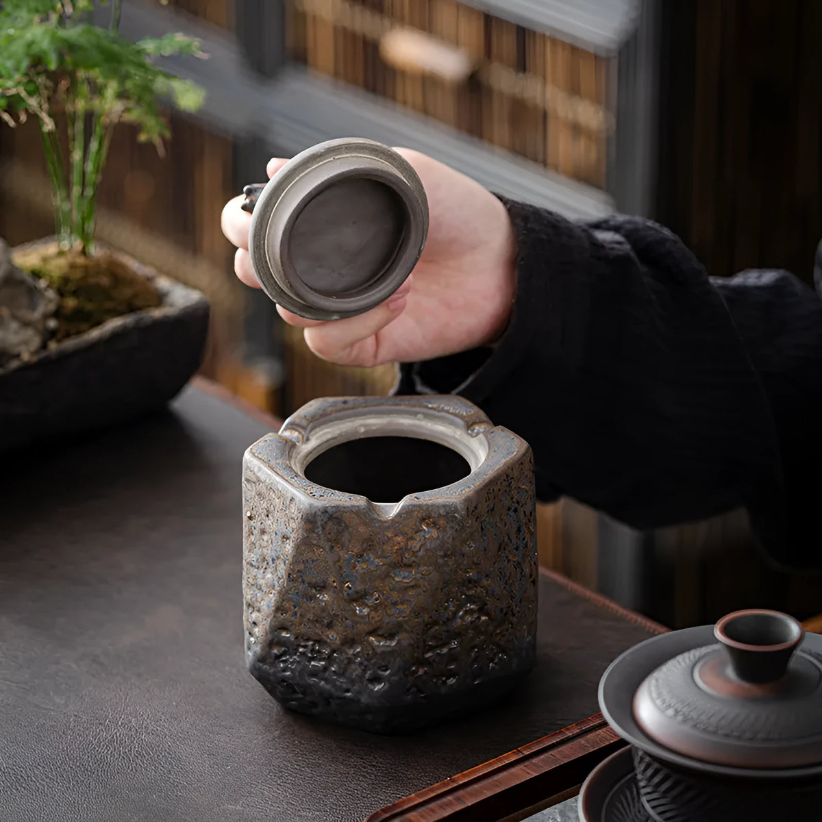 Stoneware ceramic ashtray with lid in retro Japanese style, gilt pony colour, on a table