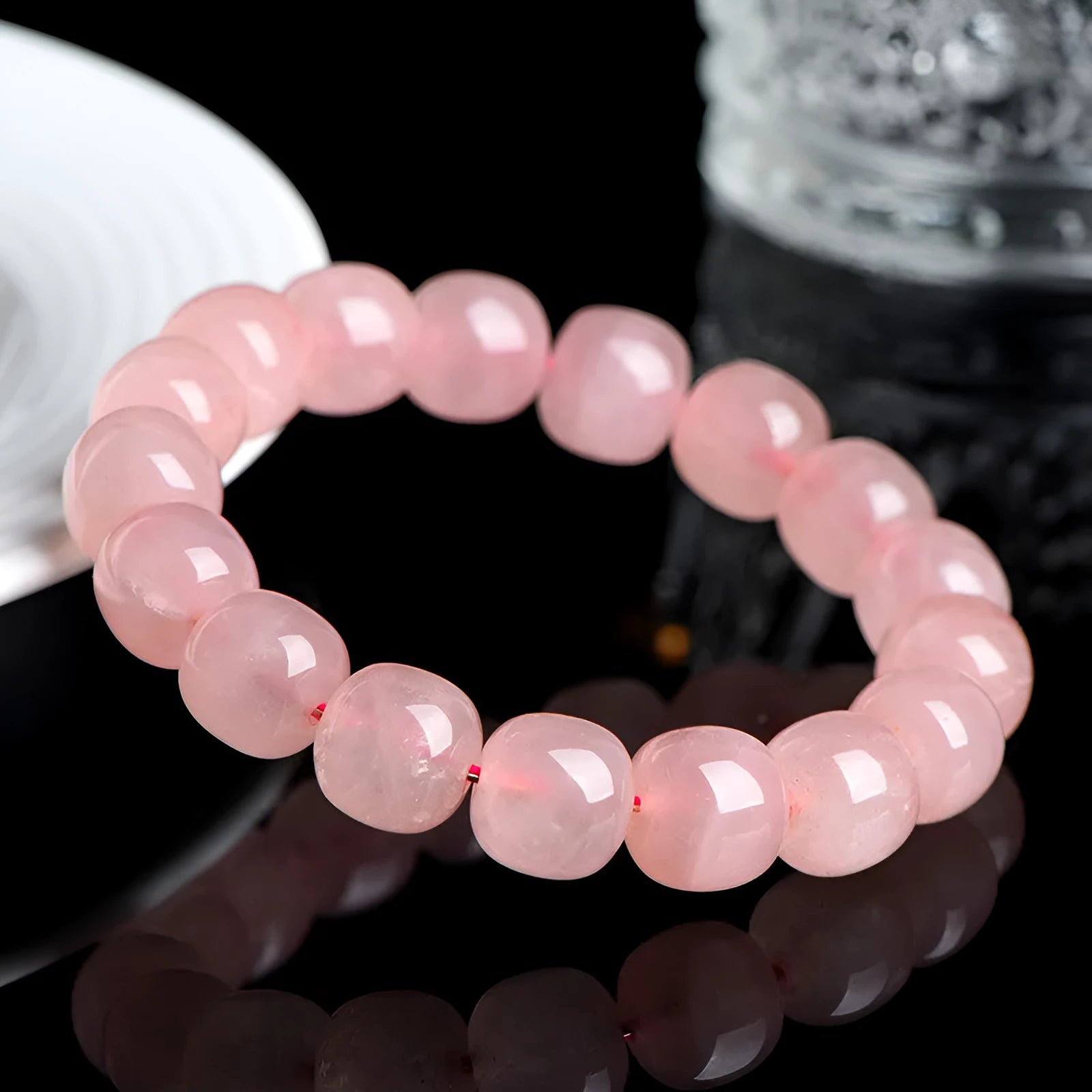 Natural pink crystal barrel bead bracelet with geometric design on wrist