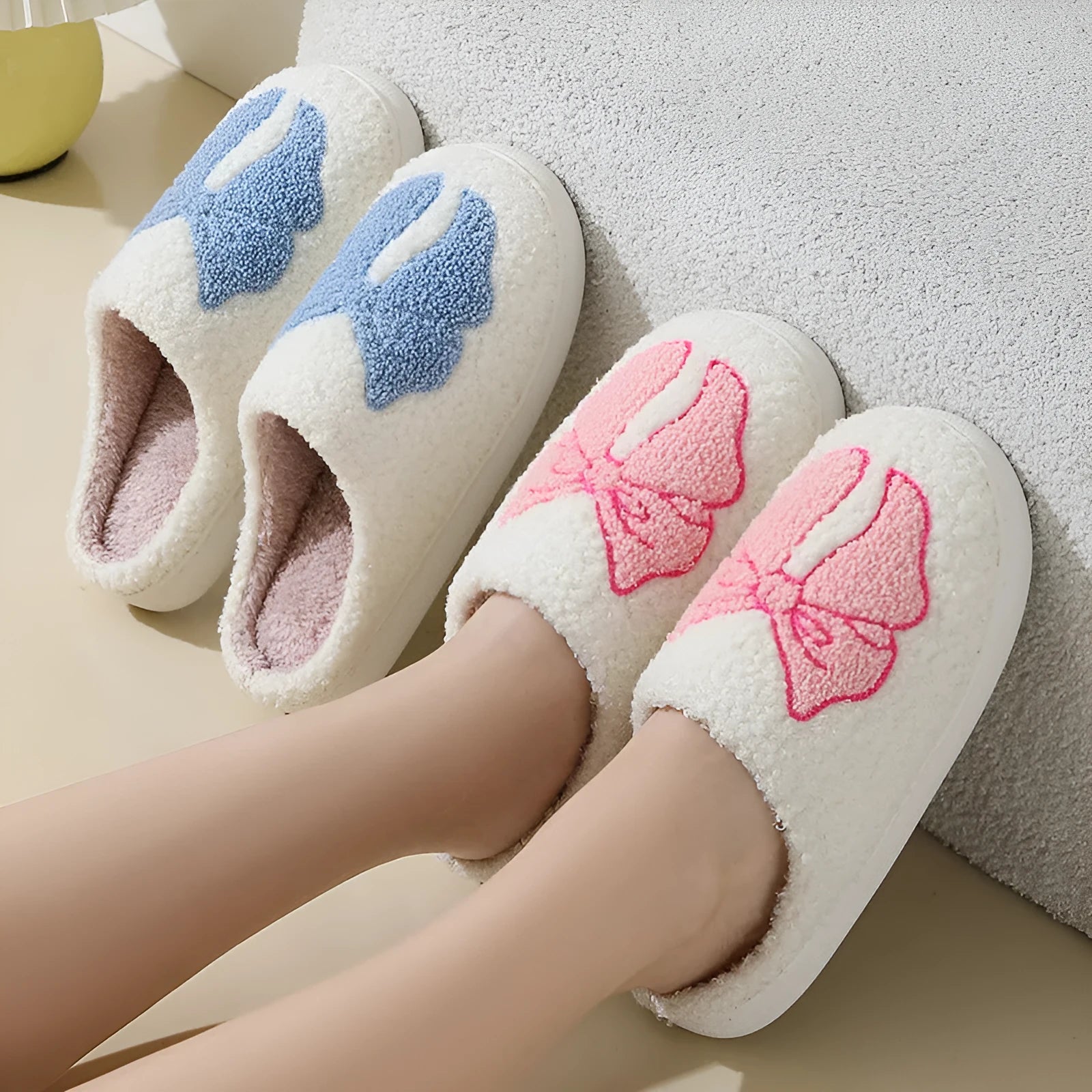Cotton slippers with cartoon bow knot design on suede upper in pink or blue colours with TPR sole