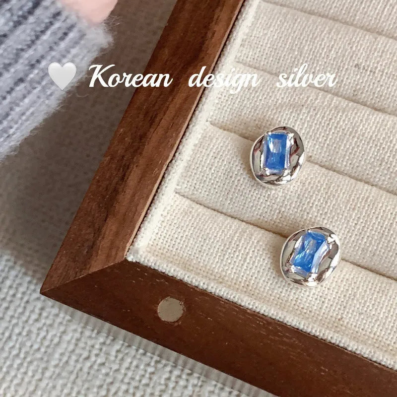 S925 sterling silver earrings with heart-wrapped oval design and blue diamond detail