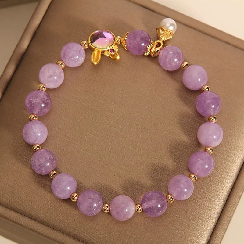 Mauve jade rabbit bracelet with a purplish red jade hare head charm on a crystal band.