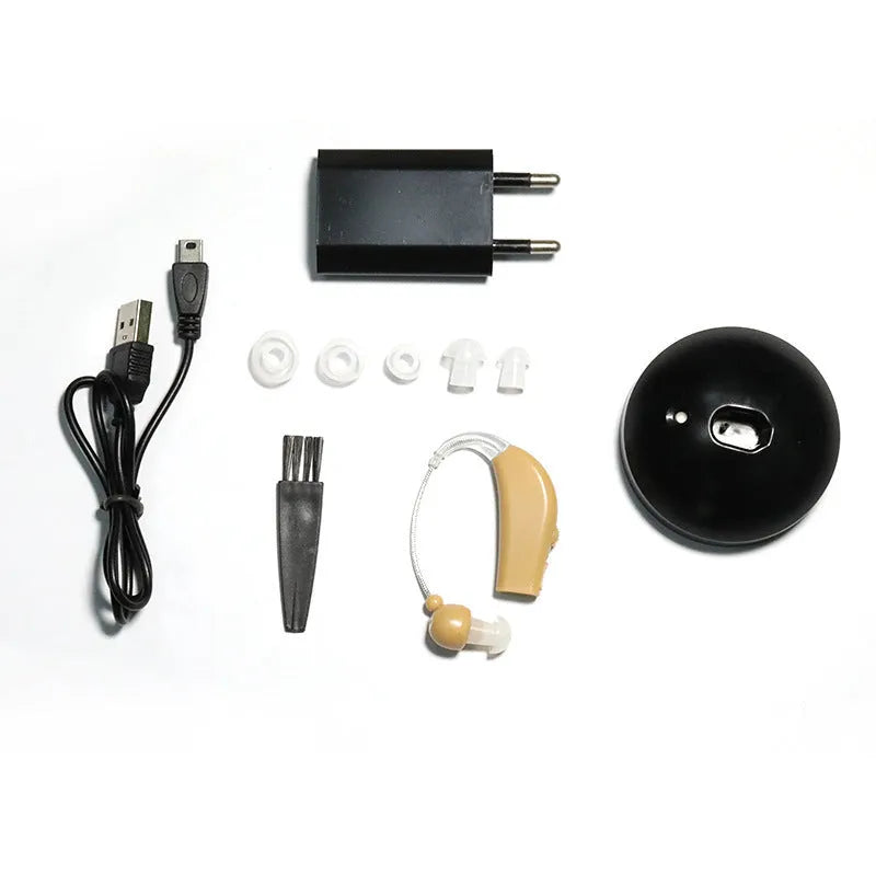 Black silicone rechargeable hearing aid amplifier with charging cable on a plain surface.