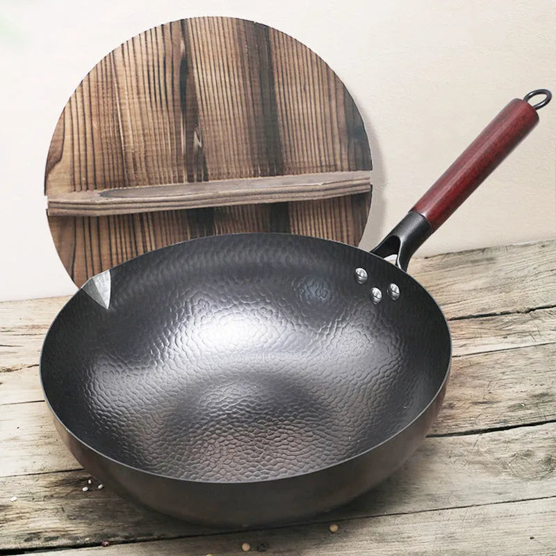 Black traditional iron wok with wooden handle, shown with glass lid.