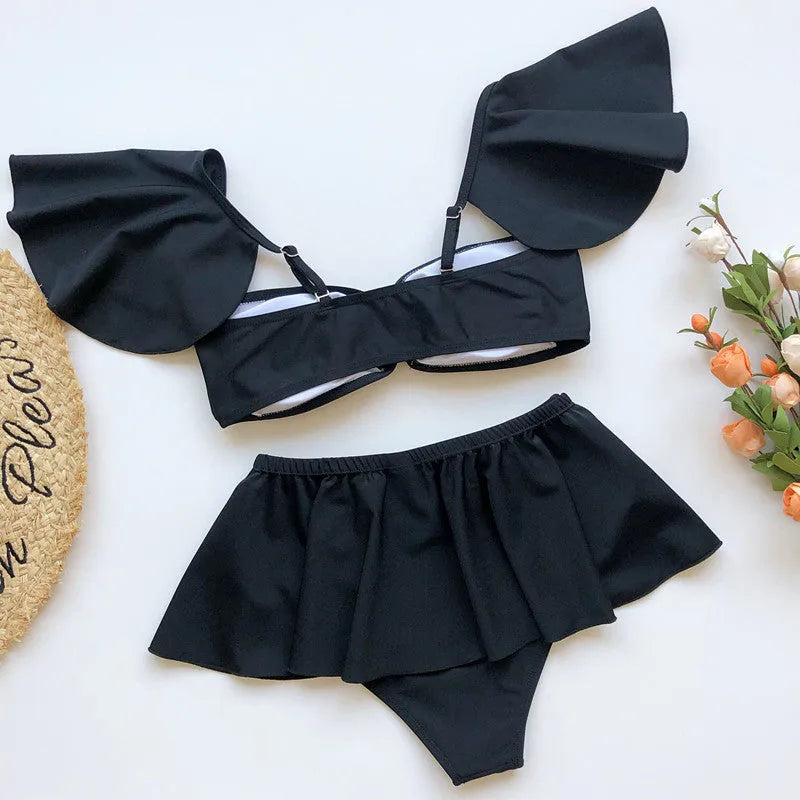 Women's red or black flounced three-piece bikini swimsuit on a mannequin.