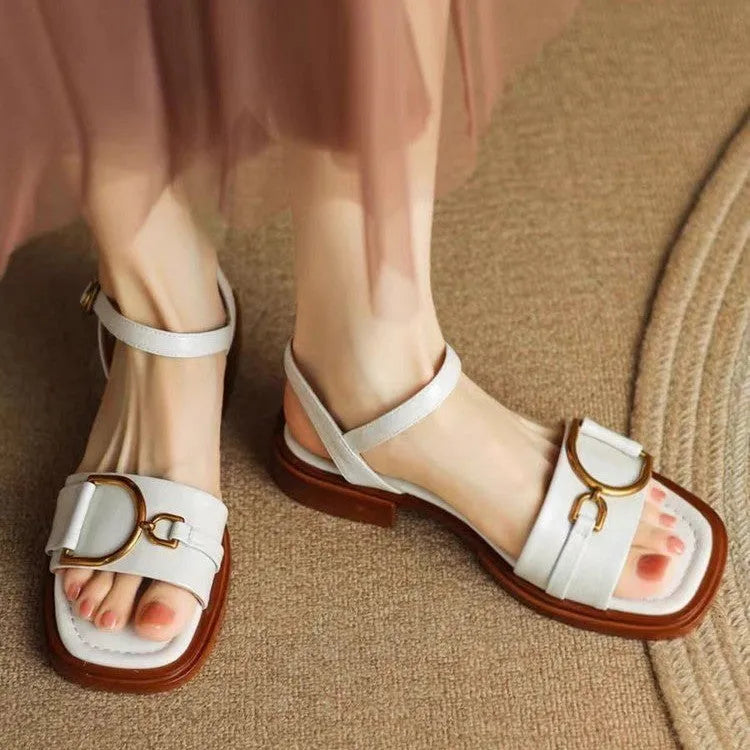Women's black leather sandals with a thick rubber sole and a round toe, fastened with a button.