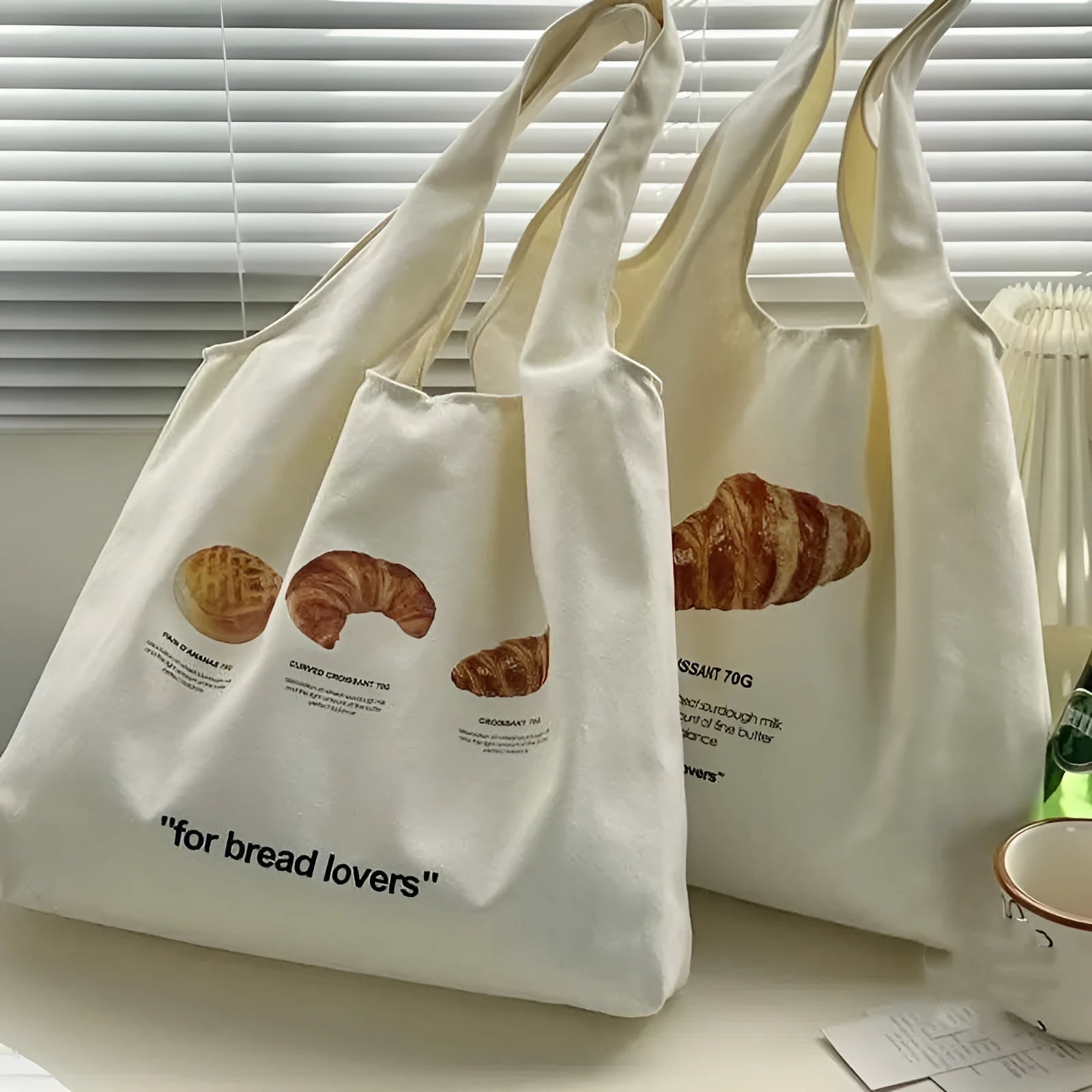 Beige canvas tote bag with croissant-shaped shoulder design and wide 44cm structure