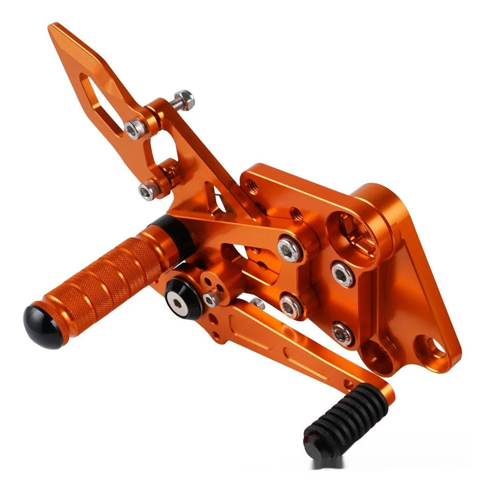KTM Duke foot pedal bracket assembly for raised rear shift pedal in black or orange