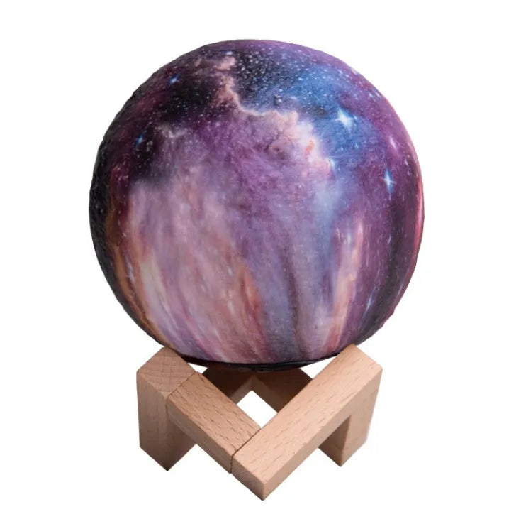 3D-printed spherical lunar night light with remote control on a dark surface.