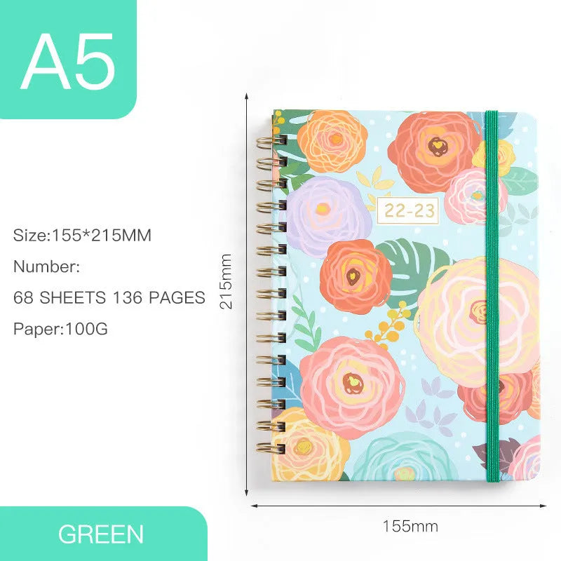 A5 spiral-bound notebook with a colourful floral design cover, lying open on a table.