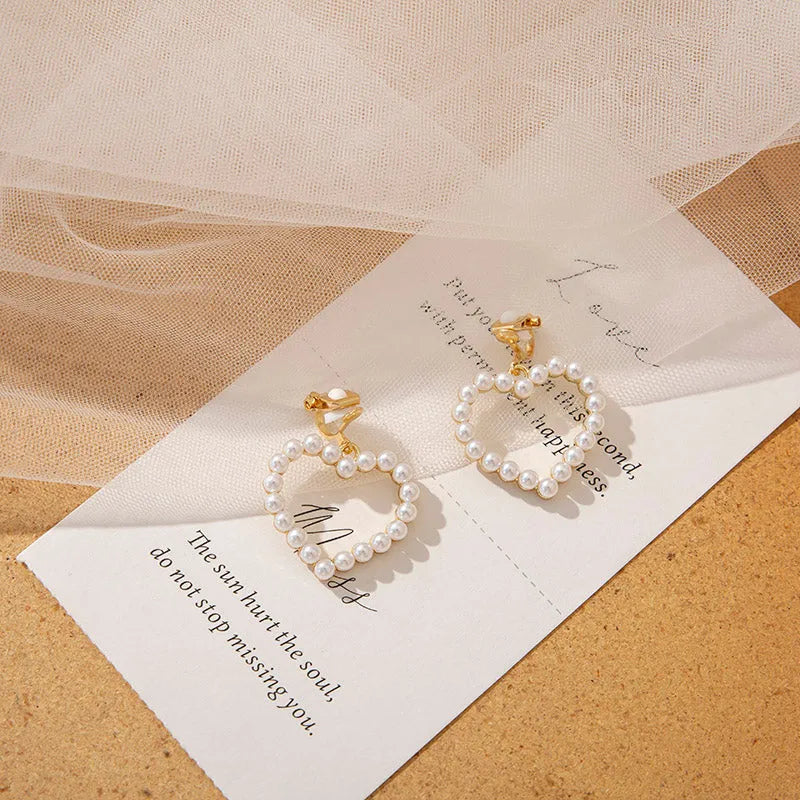 Heart shaped ear clip earrings for women with imitation pearl heart detail and retro round face, 1 pair