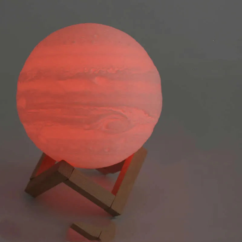 3D printed white moon lamp glowing on a wooden stand, showing detailed lunar craters.