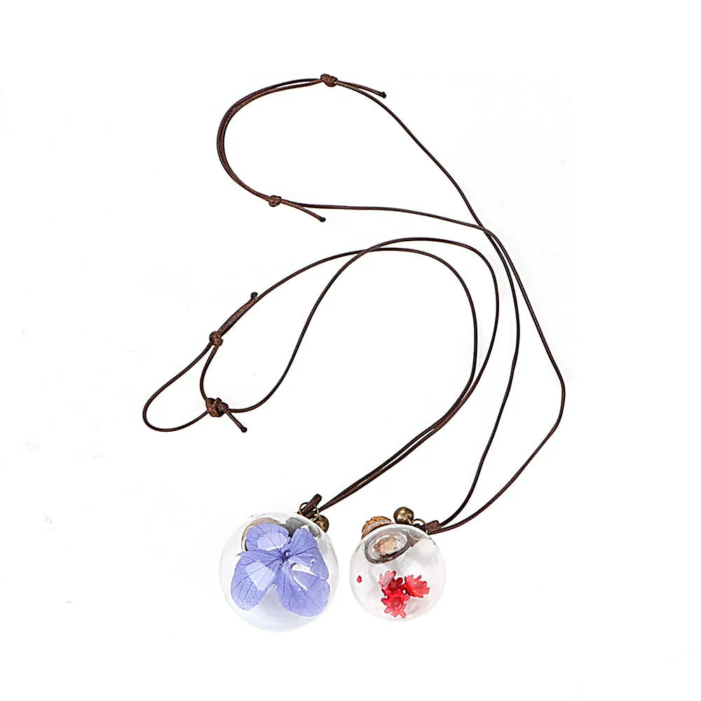 Car pendant perfume bottle with 2.8cm high borosilicate glass ball and Brazilian small star flower in Blue, Green, Pink, or White.