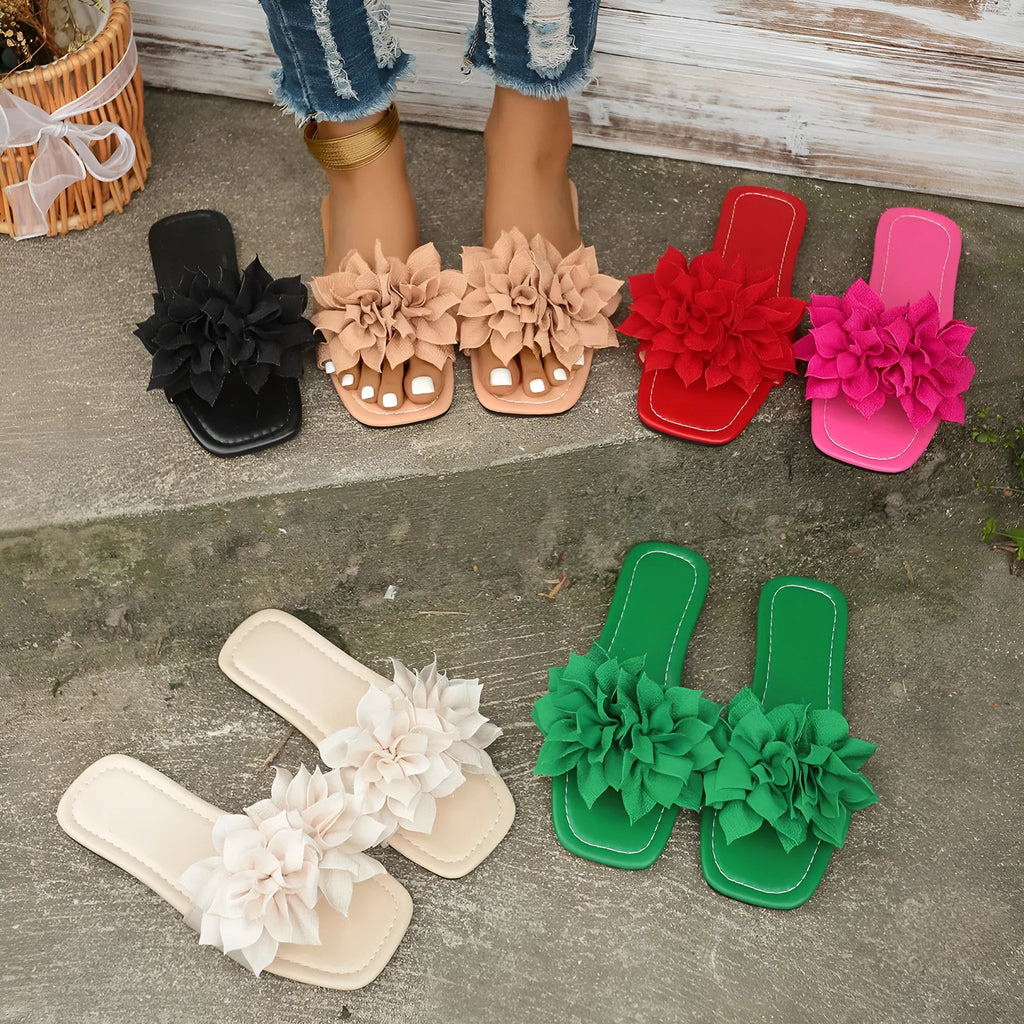 Women's flat flip-flops with flower detail on PU upper, available in apricot, black, white, red, and green