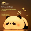 Cute cartoon panda silicone night light for children on a bedside table.