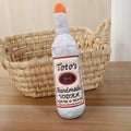 Brown plush wine bottle shaped dog toy with textured molar surface and squeaker