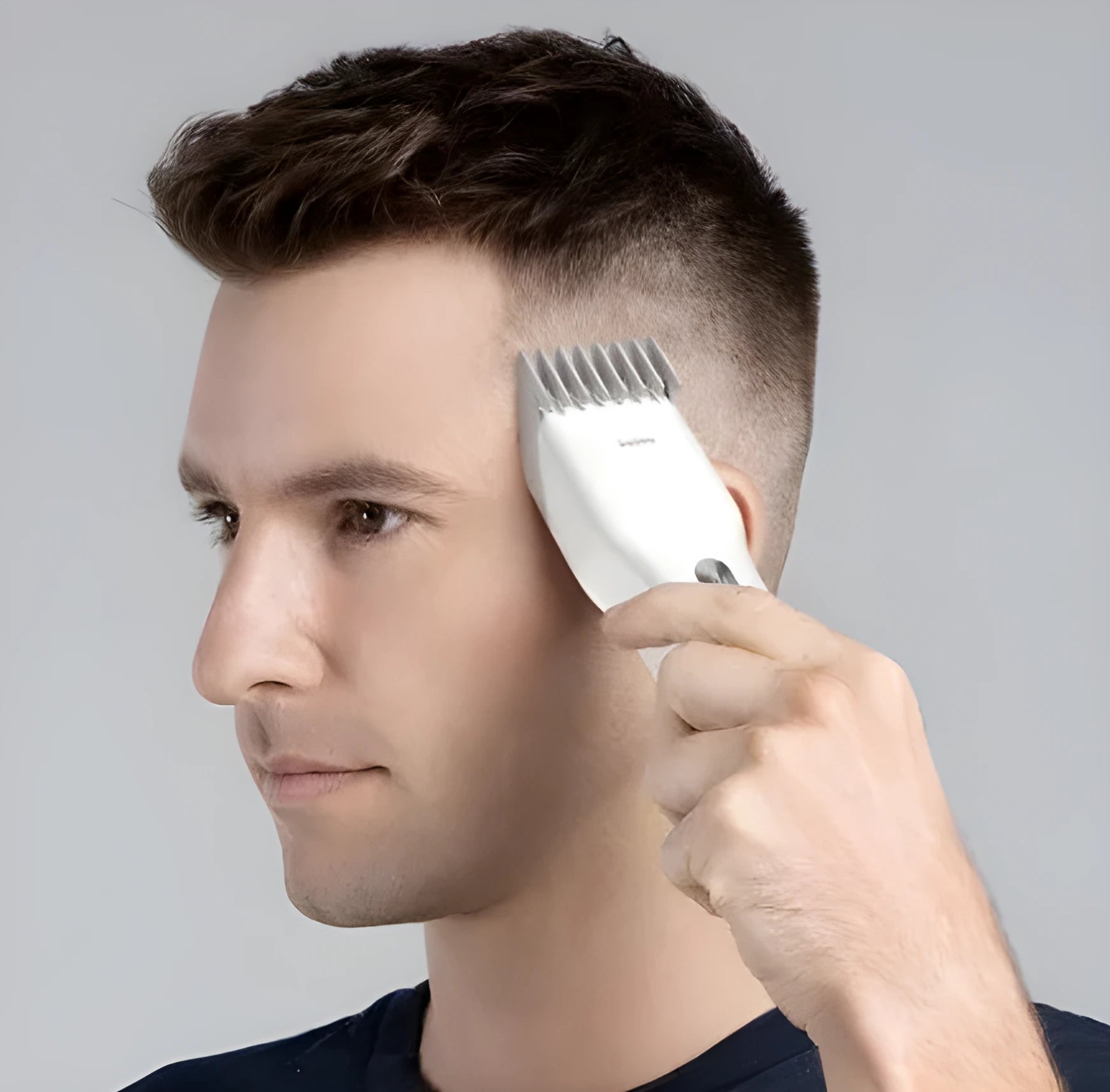 Black cordless hair clipper with a sliding length adjustment comb on a white background.