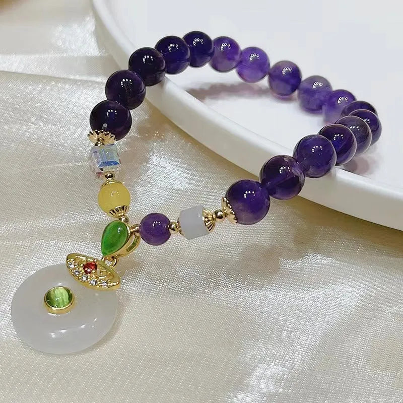 Purple crystal bracelet with geometric shapes, money bag pendant and peace buckle on wrist