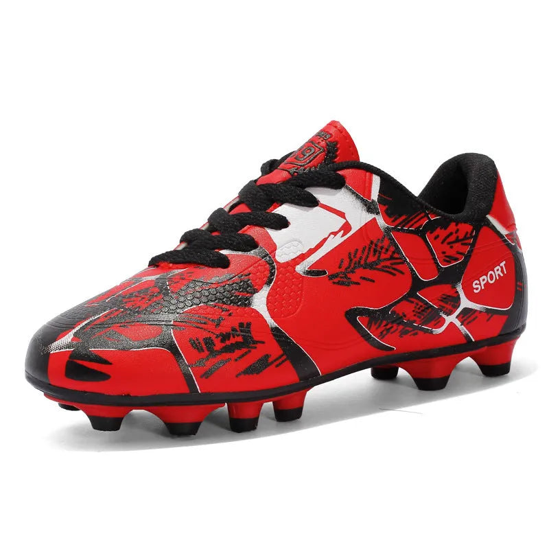 Red low-top soccer shoes with synthetic leather upper and spike outsole on natural grass