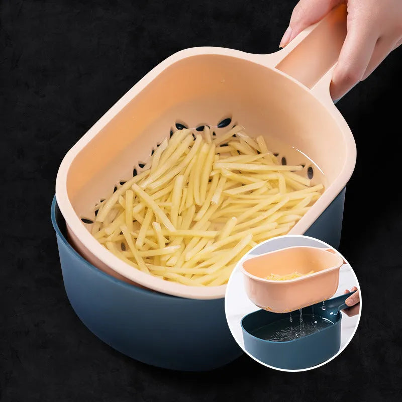 Dark blue manual vegetable cutter with four stainless steel blades, a hand protection guard, and a drain basket on a kitchen counter.