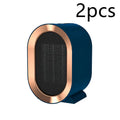 Compact black desktop electric fan heater with mechanical dial controls on a wooden desk.