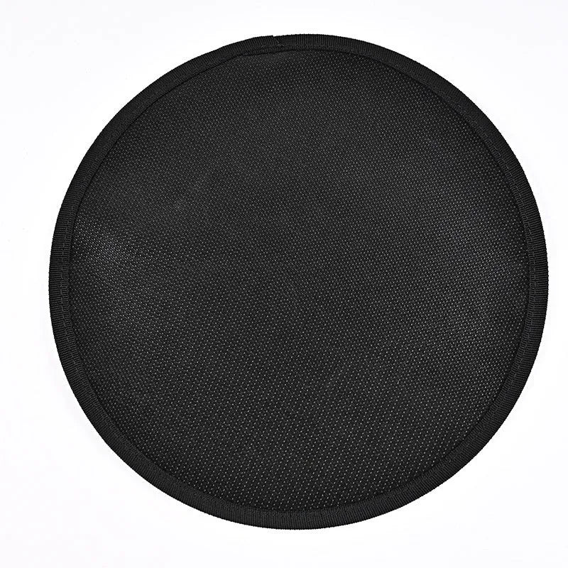 Black round barbecue fireproof mat with oil-resistant surface on a garden patio