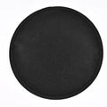 Black round barbecue fireproof mat with oil-resistant surface on a garden patio