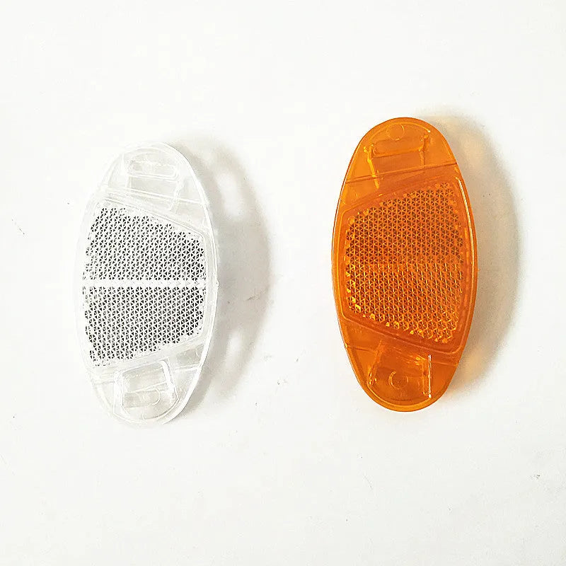 White and yellow plastic bicycle spoke reflectors for front and rear wheel safety.