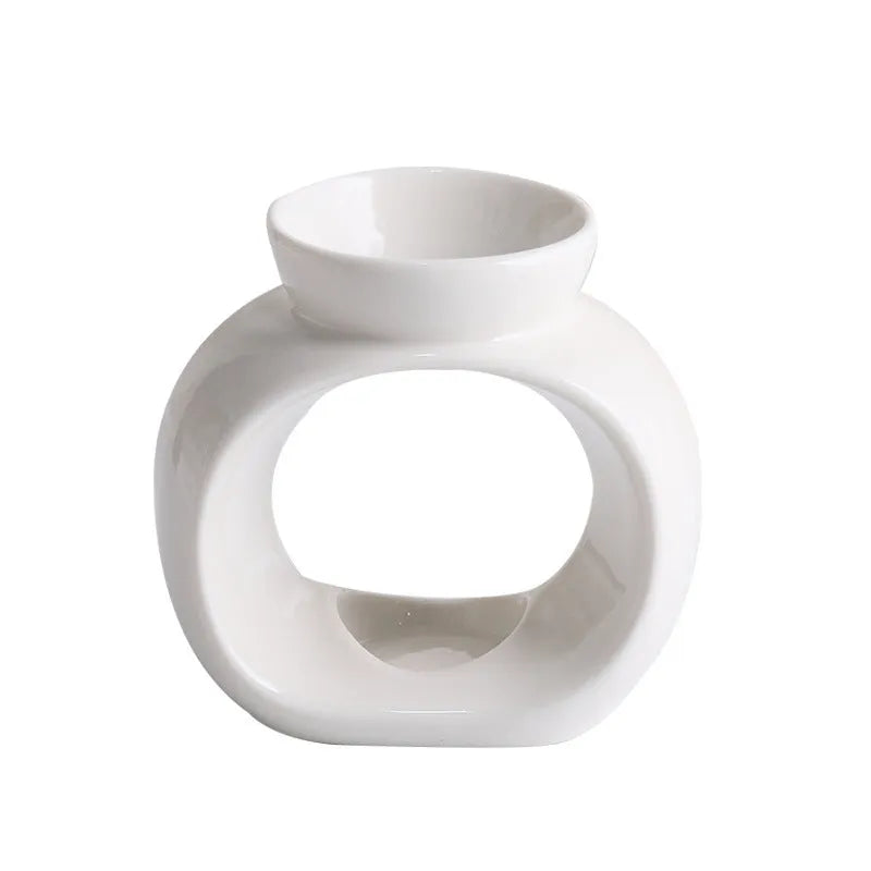 White glazed porcelain Nordic style aromatherapy stove ornament on a table.