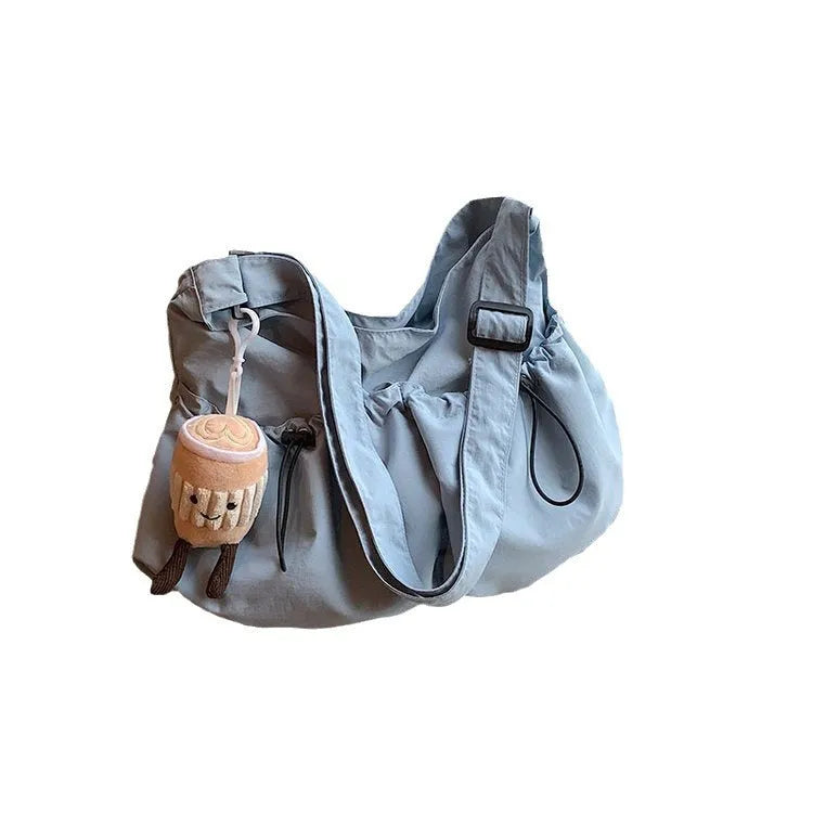 Ultra-light pleated crossbody student cloth bag in folded position showing split pocket design
