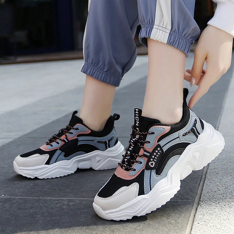 White women's casual mesh sports shoes with a thick sole, buckle detail, and round toe on a plain background.