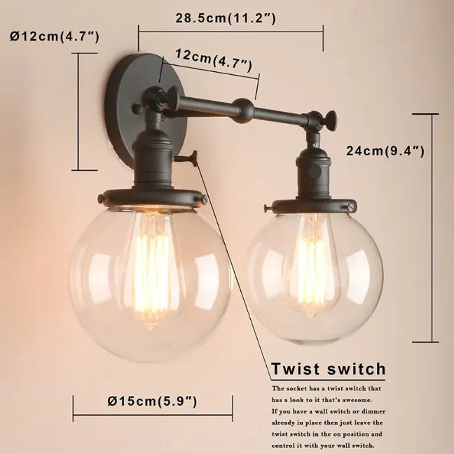 Double headed black iron wall lamp with spherical glass shades on a wall