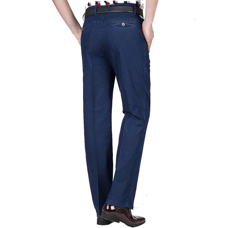 Men's loose fit high waist blue denim jeans on a plain background.
