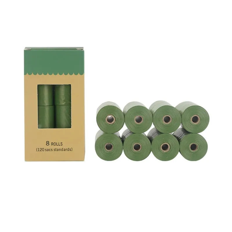 Roll of green EPI degradable pet waste bags next to a time capsule dispenser on a grass background.
