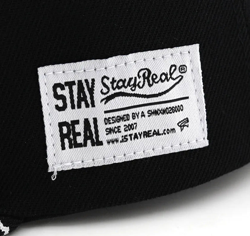 Black and white adjustable cotton baseball cap with embroidered lettering and dome crown.