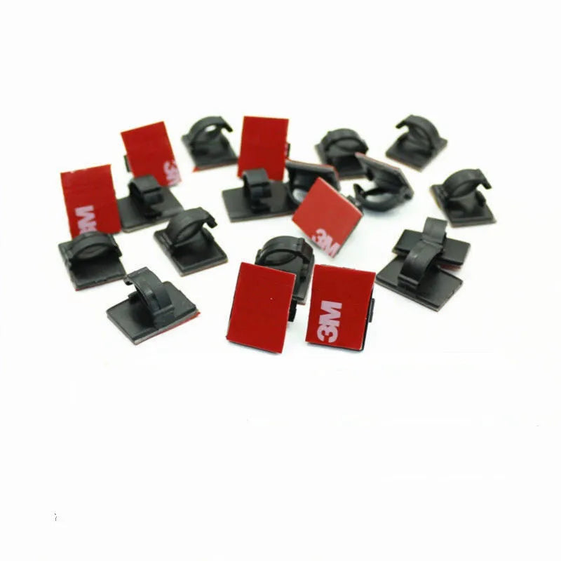 Black and white self-adhesive plastic clamps for organising car wiring cables.