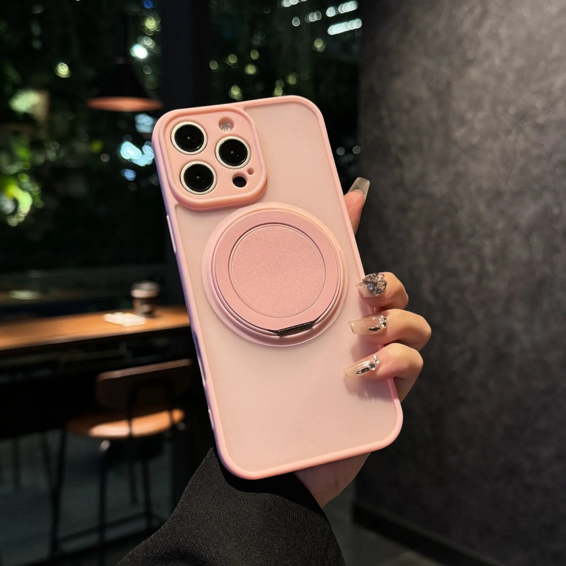 Frosted black phone case with integrated rotating magnetic bracket for IPhone 17 models on a table.
