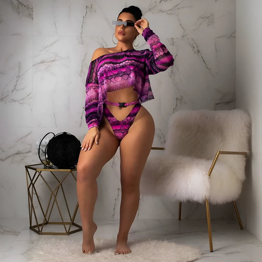Women's purple snakeskin print bikini set with long sleeves and split shorts laid flat