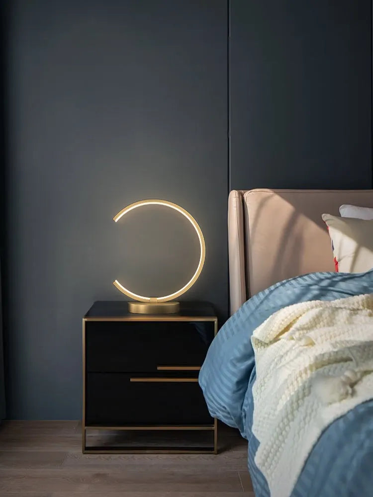 All copper Nordic style table lamp with tri-tone LED light, push button switch, on a wooden desk
