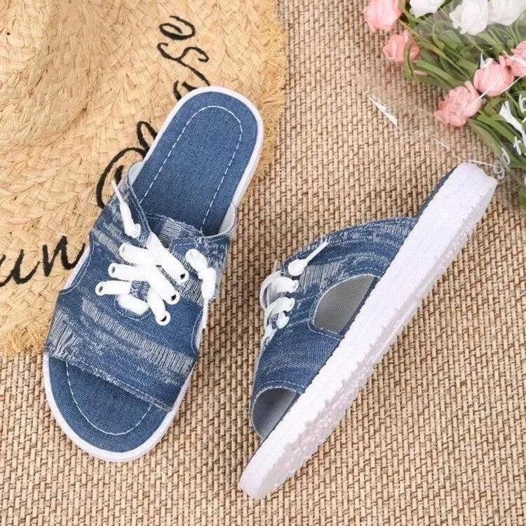Blue women's flat canvas slippers with a cloth upper and rubber sole.