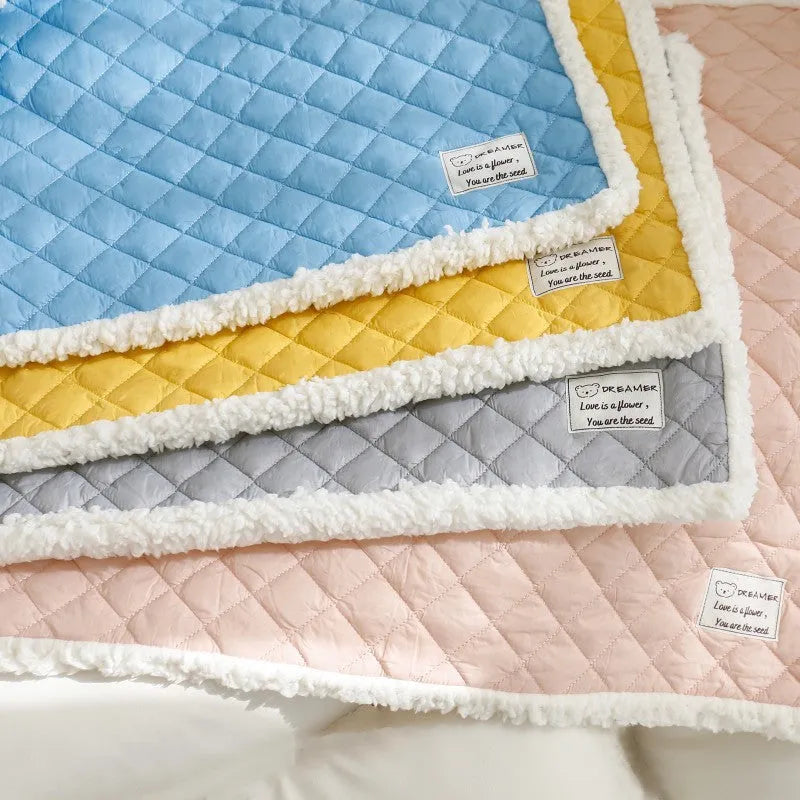 Quilted terry cloth cat blanket in blue, shown alongside pink, yellow, and grey colour options.