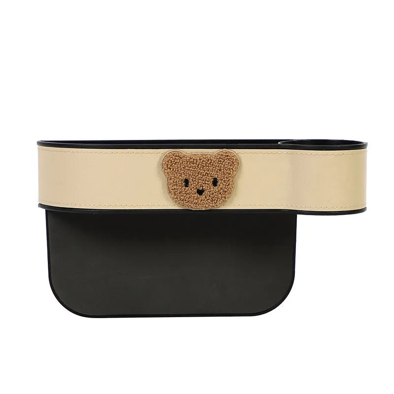 Leather car seat gap storage box with a cartoon bear design, shown hanging between vehicle seats.