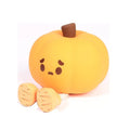 Pumpkin-shaped silicone night light with soft orange glow on wooden bedside table