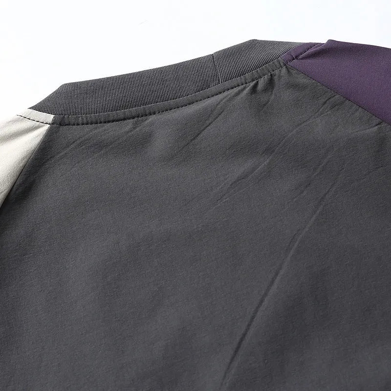 Dark grey loose fit t-shirt with light coloured raglan sleeves on a hanger